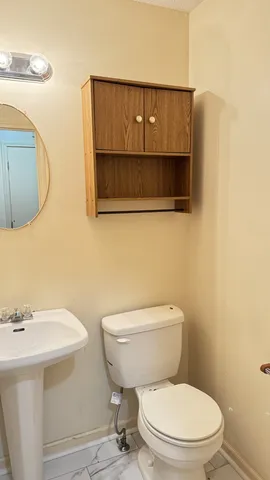 a bathroom with a toilet a sink and mirror
