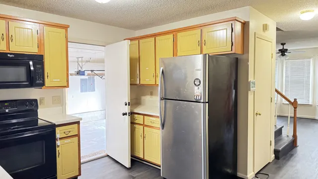 a kitchen with stainless steel appliances granite countertop a refrigerator and a stove top oven