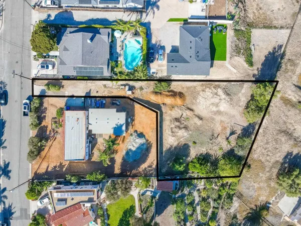 an aerial view of a house with a yard and large trees