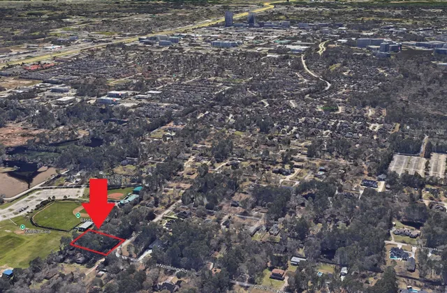 an aerial view of residential house with outdoor space and trees all around
