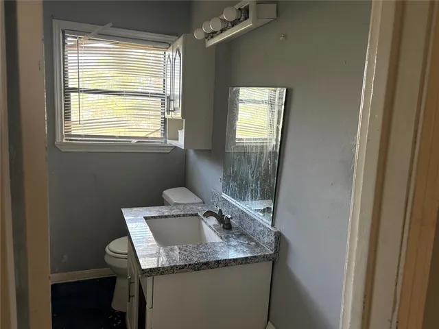a bathroom with a granite countertop sink a mirror and a window