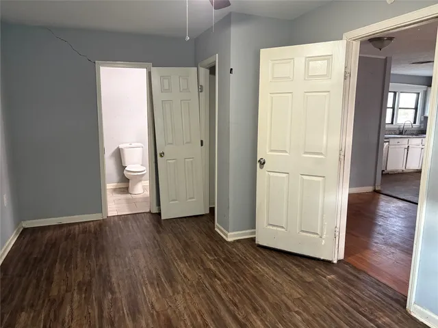 a view of a hallway with wooden floor and closet