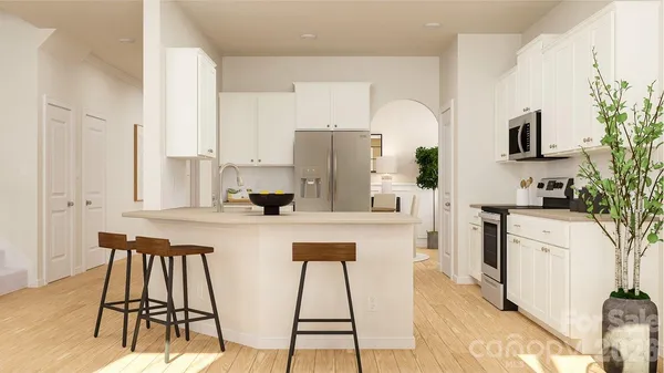 a kitchen with stainless steel appliances a table and chairs in it