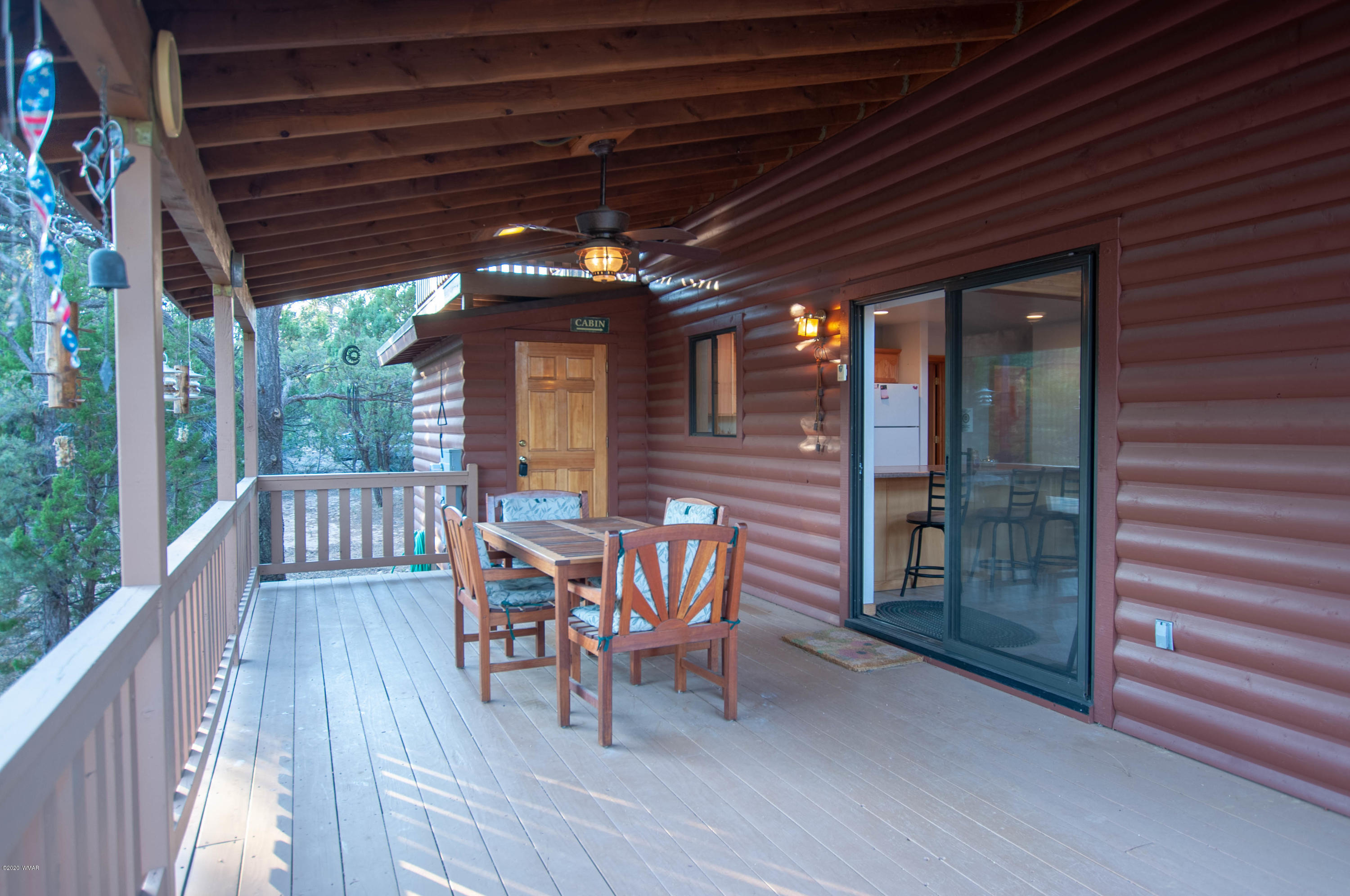 2836 Lodgepole Road Overgaard, AZ 85933 - Photo 17 of 25 a patio with wooden floor a yard a table and chairs