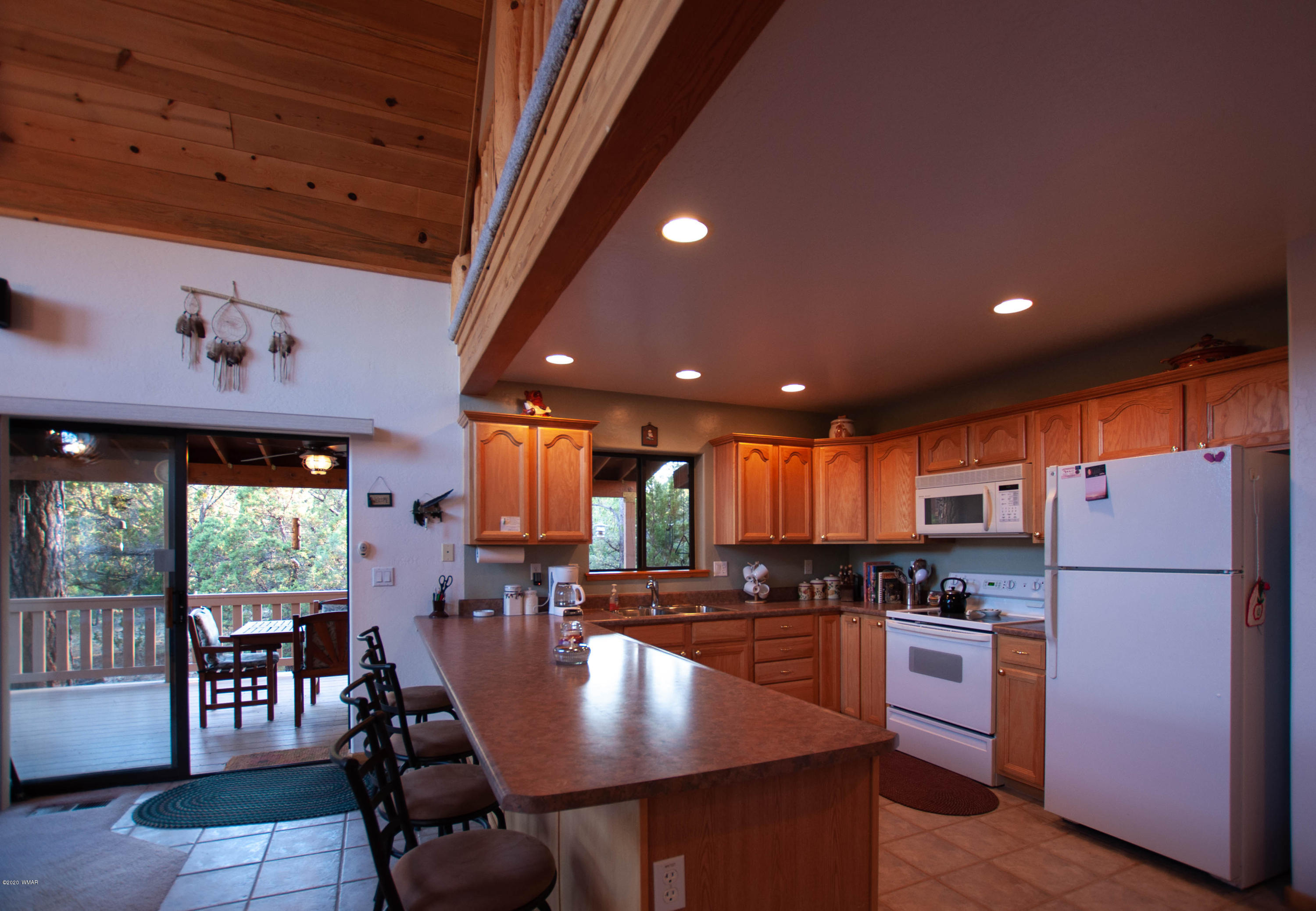 2836 Lodgepole Road Overgaard, AZ 85933 - Photo 6 of 25 a kitchen with a refrigerator a stove dining table and chairs