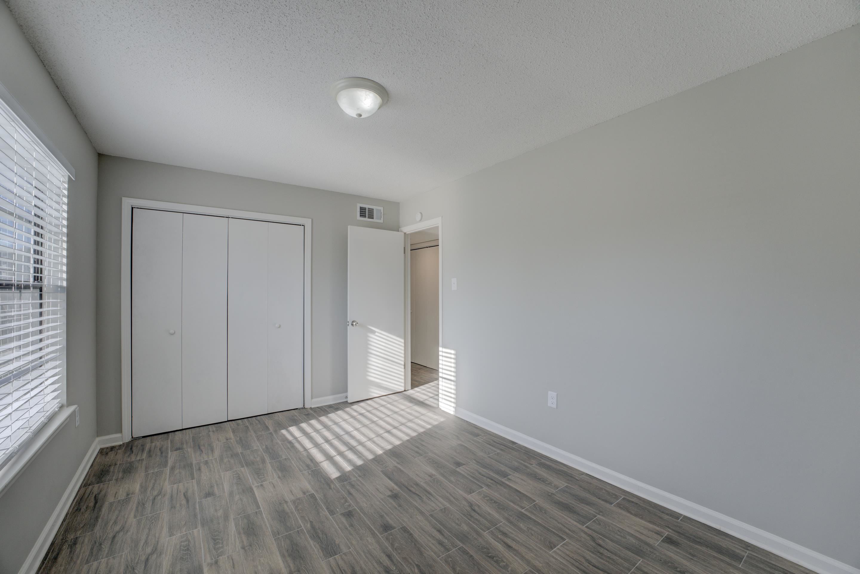 3808 Haynes Road Bartlett, TN 38133 - Photo 18 of 24 Unfurnished bedroom with a closet, dark hardwood / wood-style floors, a textured ceiling, and multiple windows