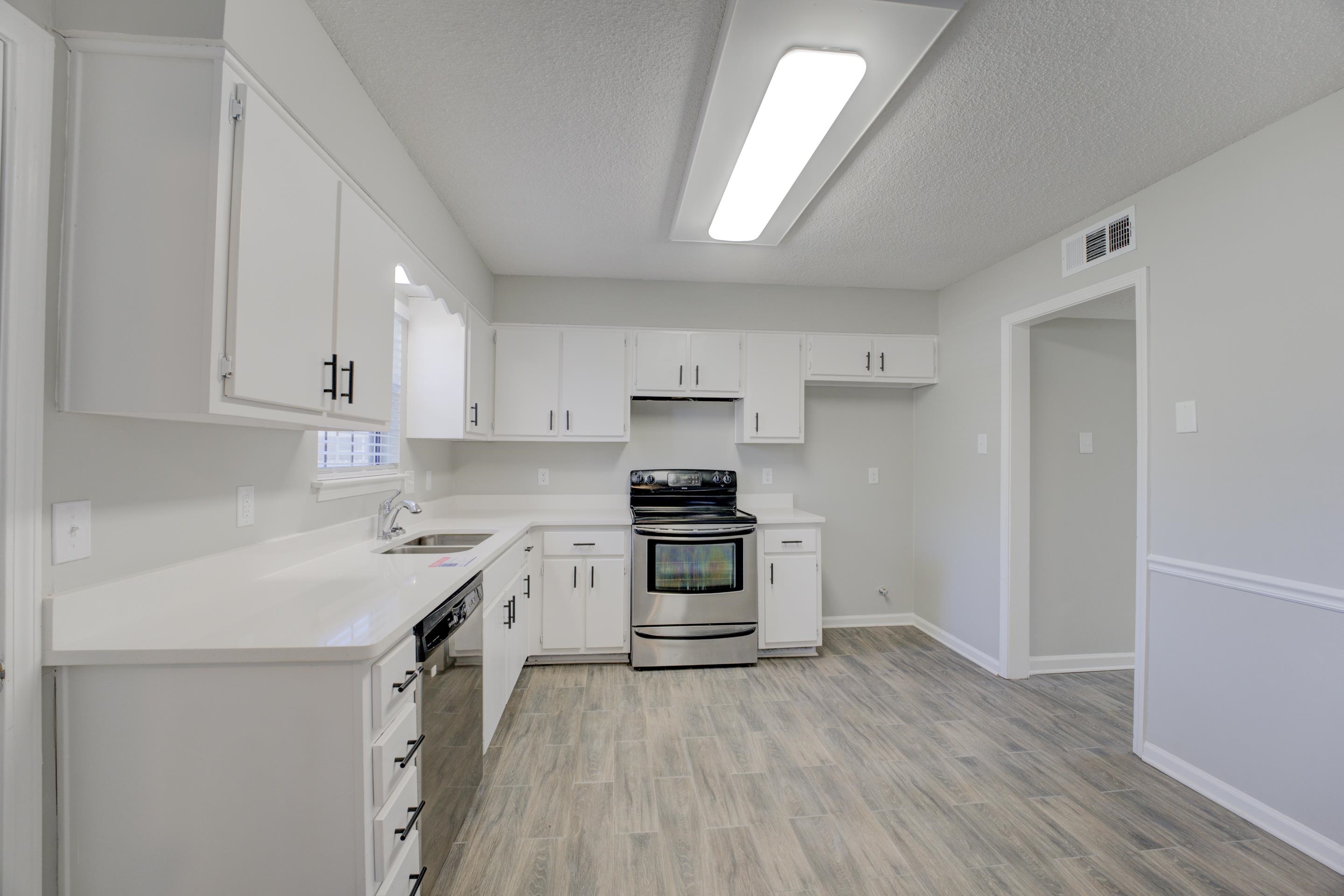 3808 Haynes Road Bartlett, TN 38133 - Photo 22 of 24 Kitchen featuring sink, appliances with stainless steel finishes, white cabinets, and light hardwood / wood-style flooring
