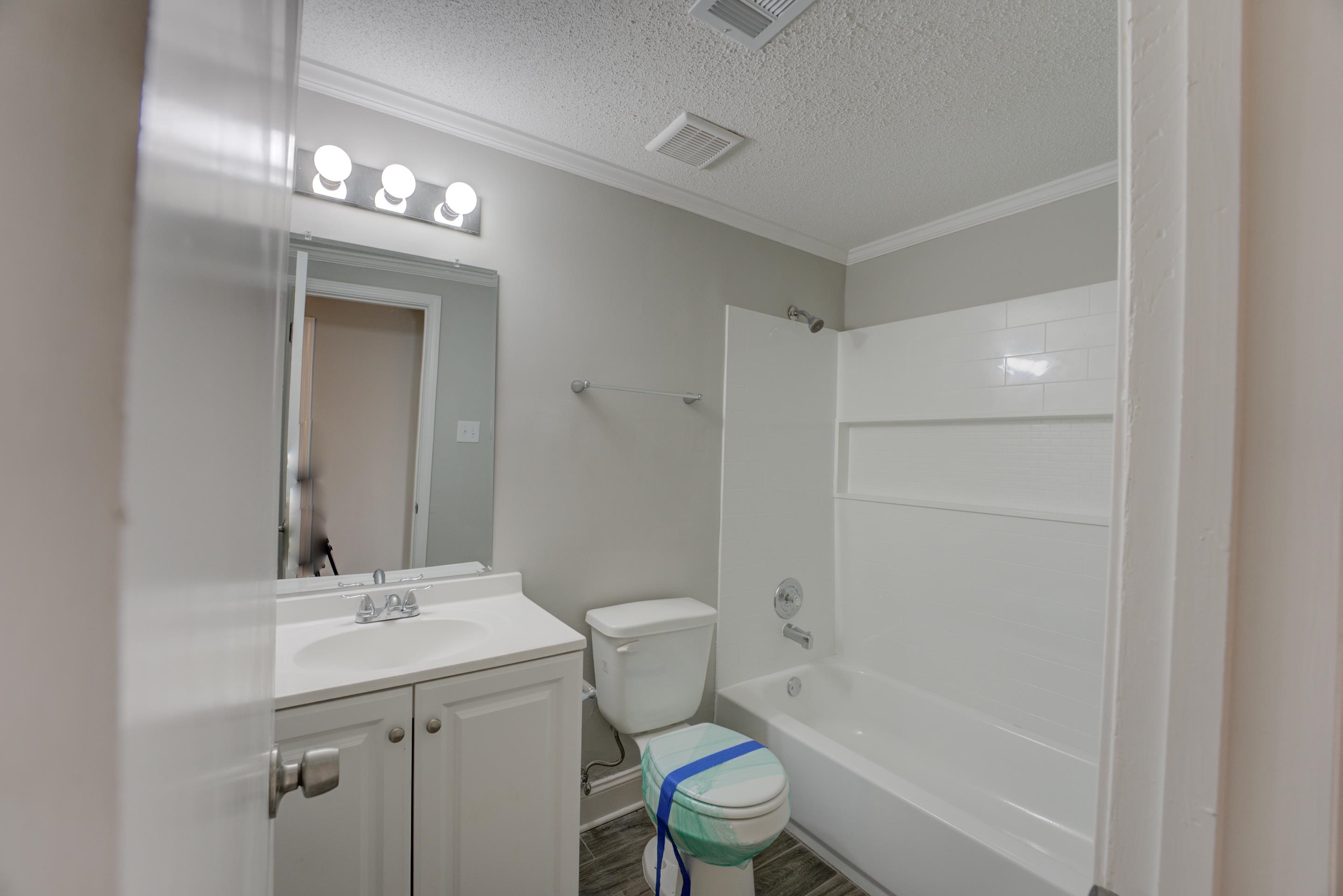 3808 Haynes Road Bartlett, TN 38133 - Photo 23 of 24 Full bathroom featuring bathing tub / shower combination, vanity, a textured ceiling, crown molding, and toilet