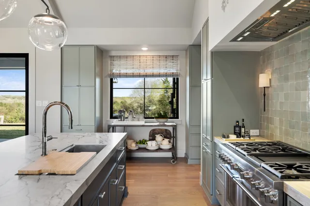 a kitchen with a stove a sink and a wooden cabinet