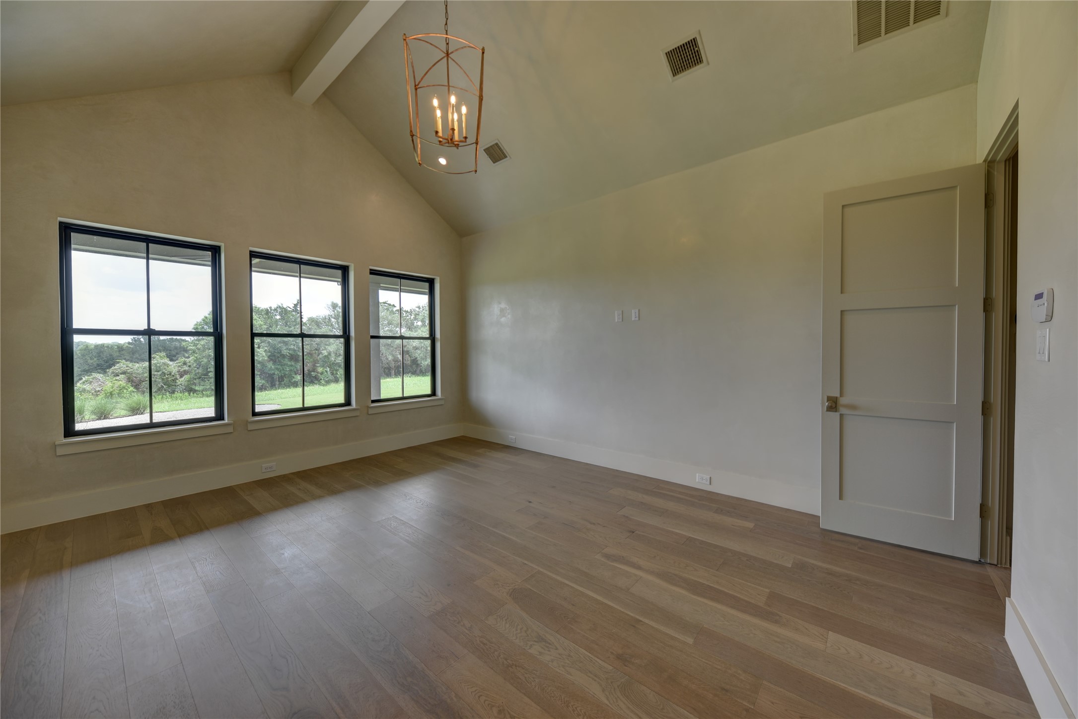 114 Turney Trace Round Top, TX 78954 - Photo 19 of 44 an empty room with wooden floor and windows