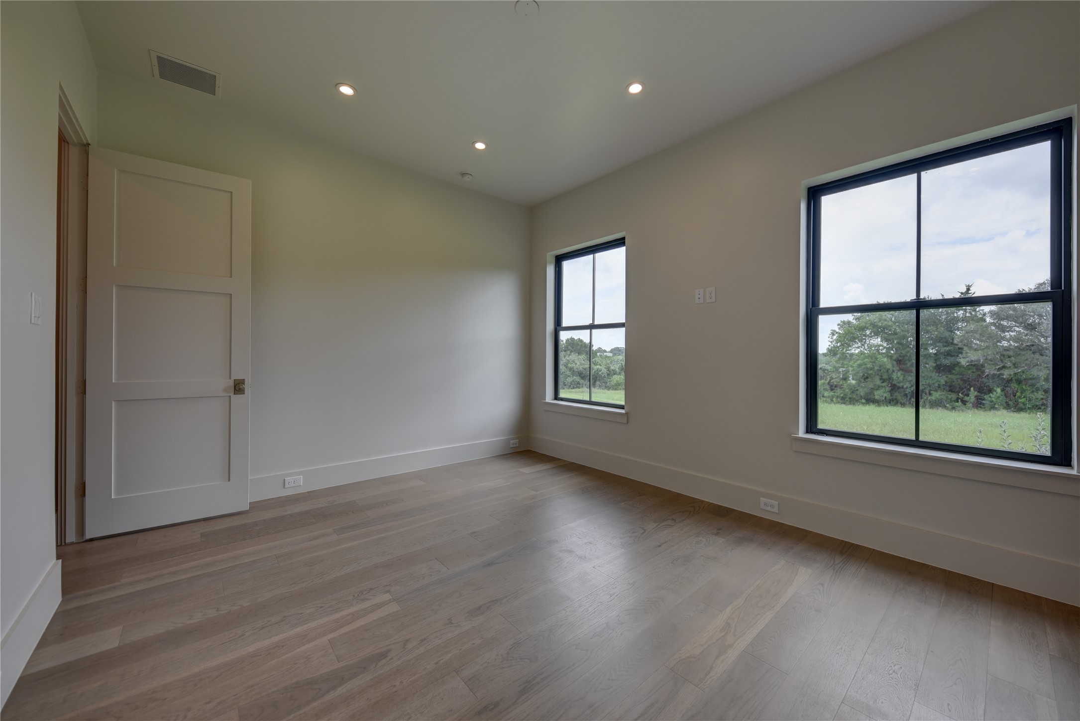 114 Turney Trace Round Top, TX 78954 - Photo 23 of 44 an empty room with wooden floor and windows