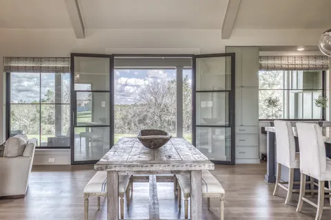a kitchen with granite countertop a table chairs stove and cabinets
