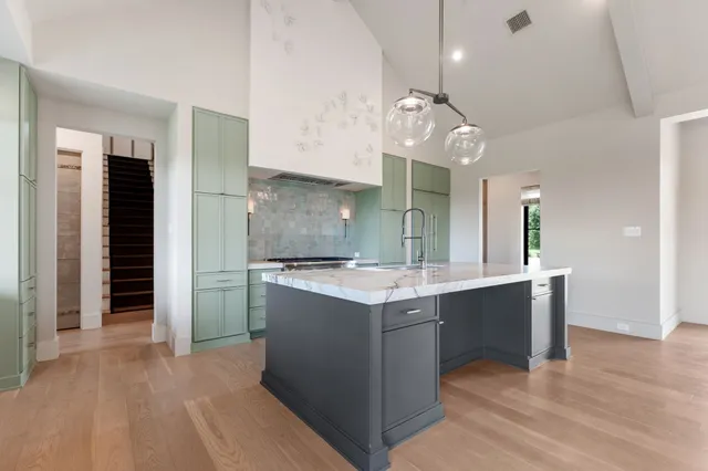 a kitchen with stainless steel appliances granite countertop a sink a stove and a refrigerator