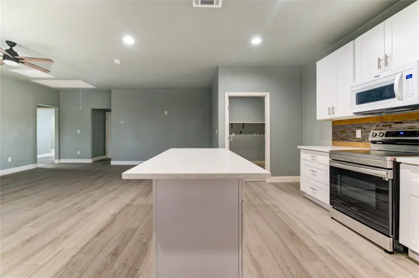 a kitchen with stainless steel appliances a white stove top oven and cabinets