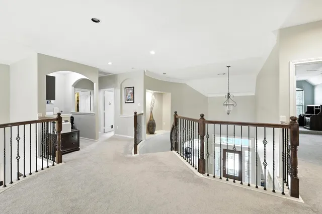 a view of a hallway with a livingroom view and staircase
