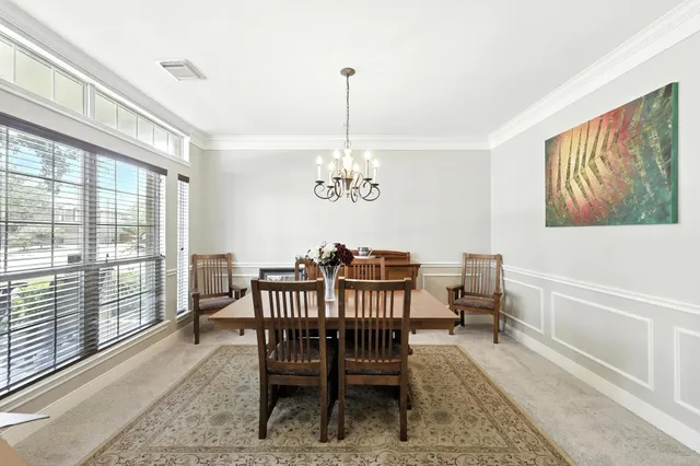 a dining room with furniture a chandelier and wooden floor