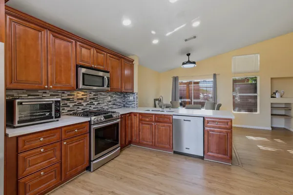 a kitchen with stainless steel appliances granite countertop wooden cabinets microwave and stove