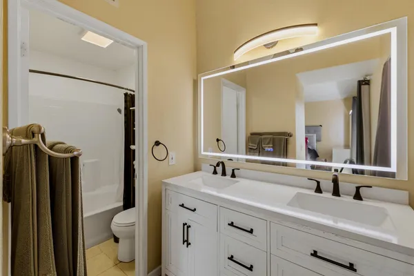 a bathroom with a sink a toilet and a mirror