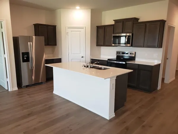 a kitchen with wooden cabinets and stainless steel appliances