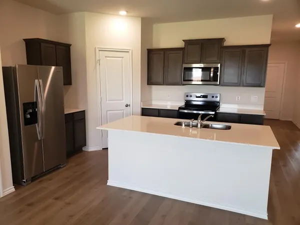 a kitchen with stainless steel appliances a refrigerator a stove a microwave and cabinets