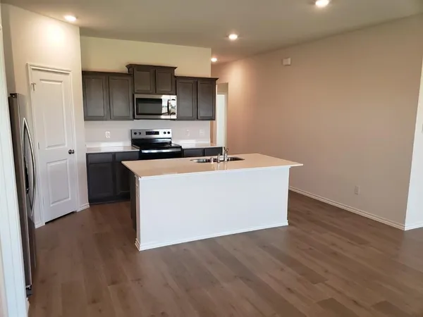 a white kitchen with granite countertop stainless steel appliances