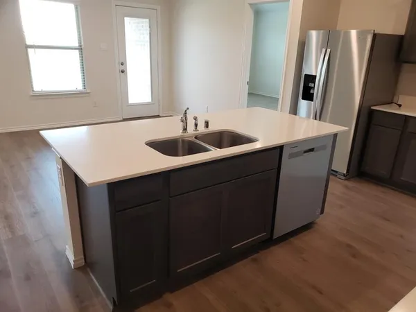 a kitchen with stainless steel appliances a sink and a refrigerator