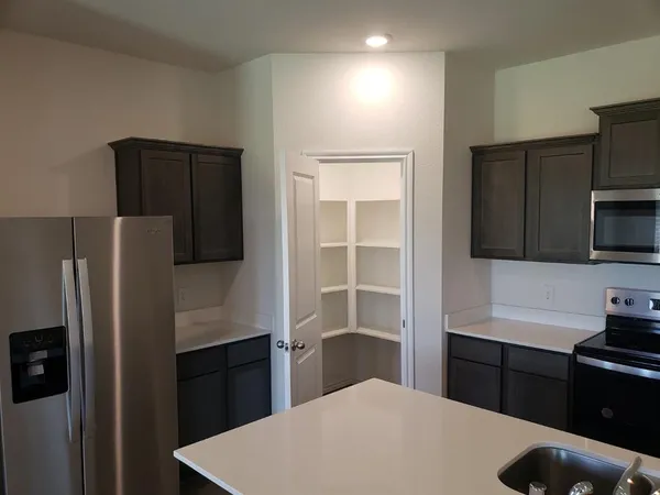 a kitchen with a refrigerator and a stove