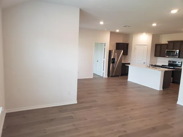 a view of kitchen with refrigerator microwave and stove