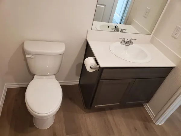 a bathroom with a toilet sink and mirror