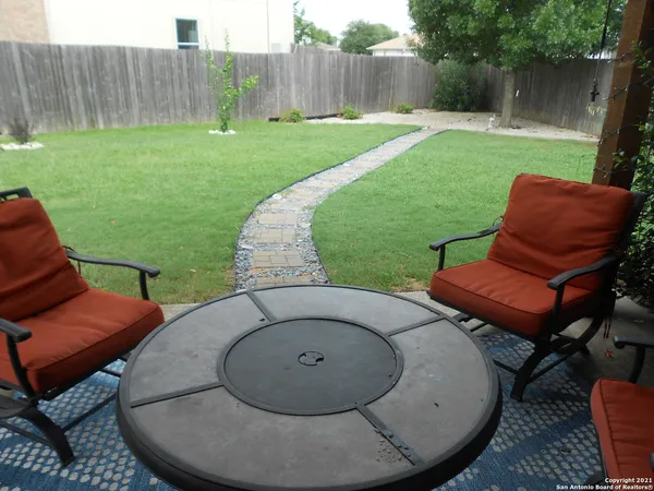 a backyard of a house with table and chairs