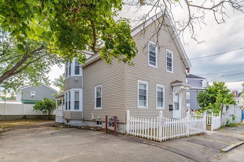a view of a house with a patio and a yard