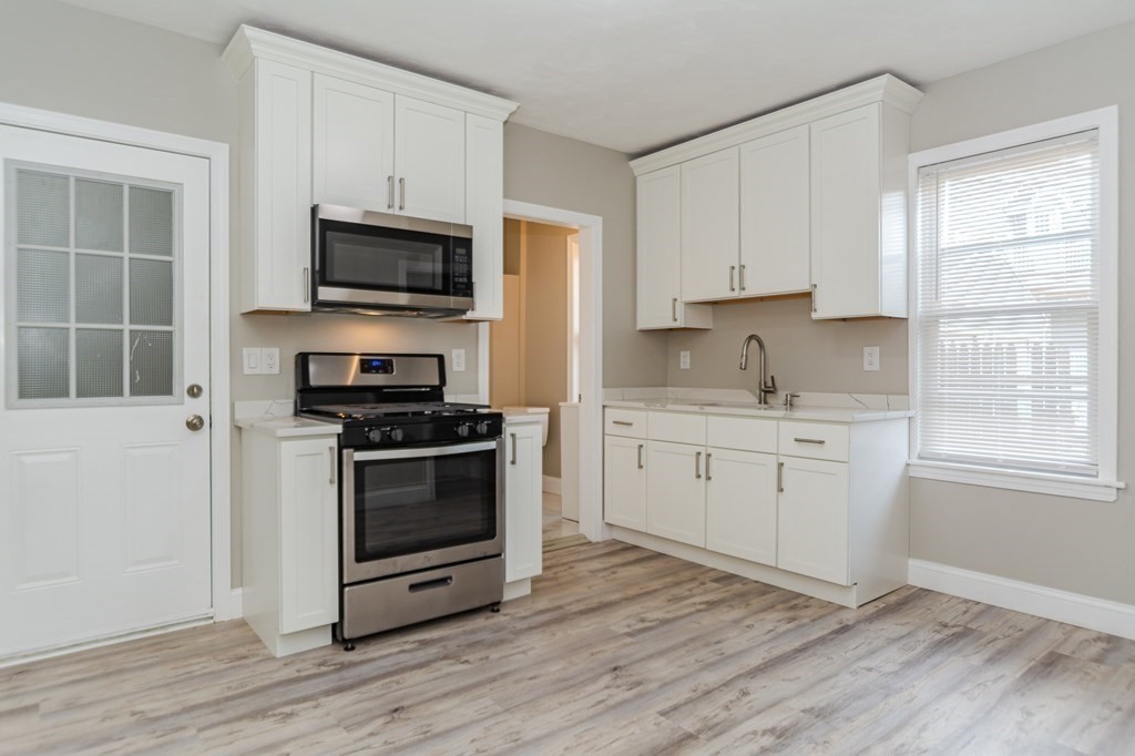 48 Washington Street Lawrence, MA 01841 - Photo 18 of 38 a kitchen with stainless steel appliances a stove microwave and sink