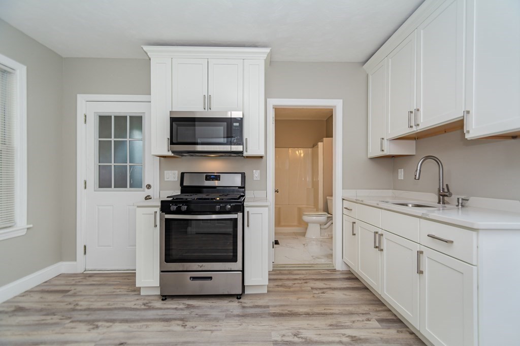 48 Washington Street Lawrence, MA 01841 - Photo 19 of 38 a kitchen with stainless steel appliances a stove sink and microwave