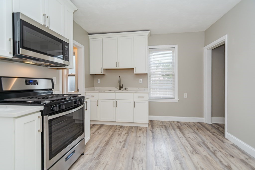 48 Washington Street Lawrence, MA 01841 - Photo 20 of 38 a kitchen with a stove a sink and a microwave