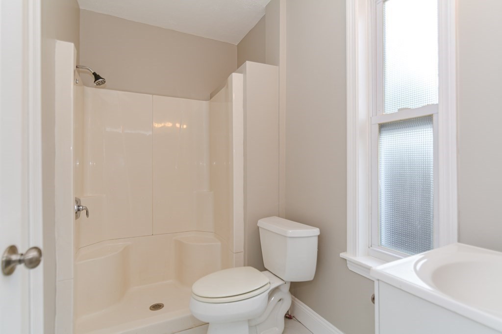 48 Washington Street Lawrence, MA 01841 - Photo 22 of 38 a white toilet sitting next to a bath tub