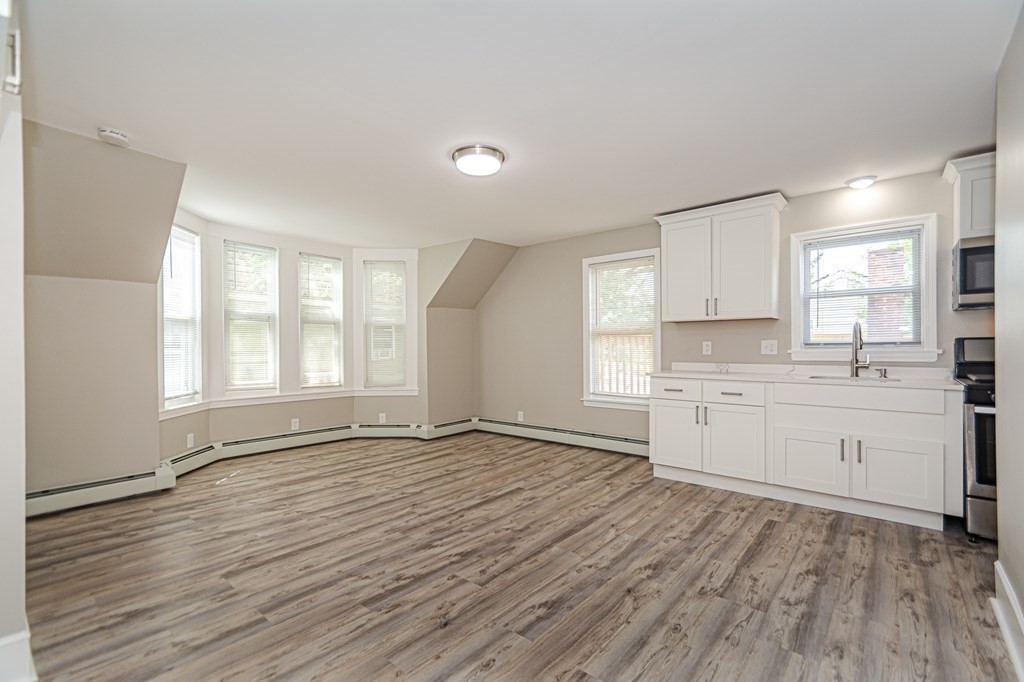 48 Washington Street Lawrence, MA 01841 - Photo 25 of 38 a view of a kitchen with wooden floor and electronic appliances