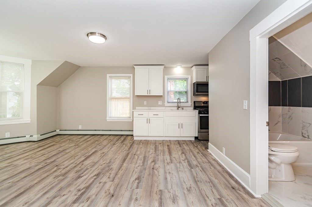 48 Washington Street Lawrence, MA 01841 - Photo 28 of 38 a view of a kitchen with wooden floor and a window
