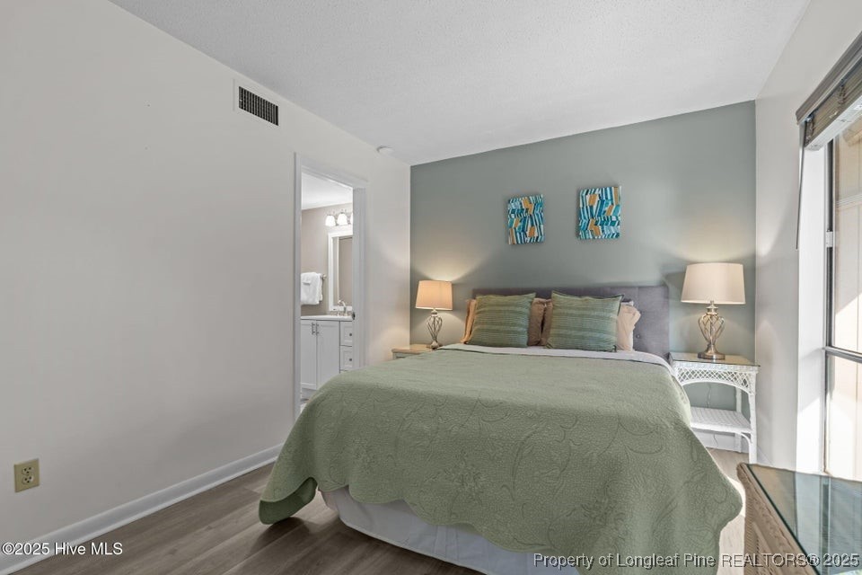 10 Pine Tree Road, Unit 211 Pinehurst, NC 28374 - Photo 14 of 36 a bedroom with a bed and wooden floor
