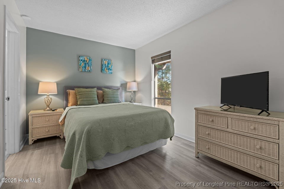 10 Pine Tree Road, Unit 211 Pinehurst, NC 28374 - Photo 16 of 36 a bedroom with a bed and a flat screen tv