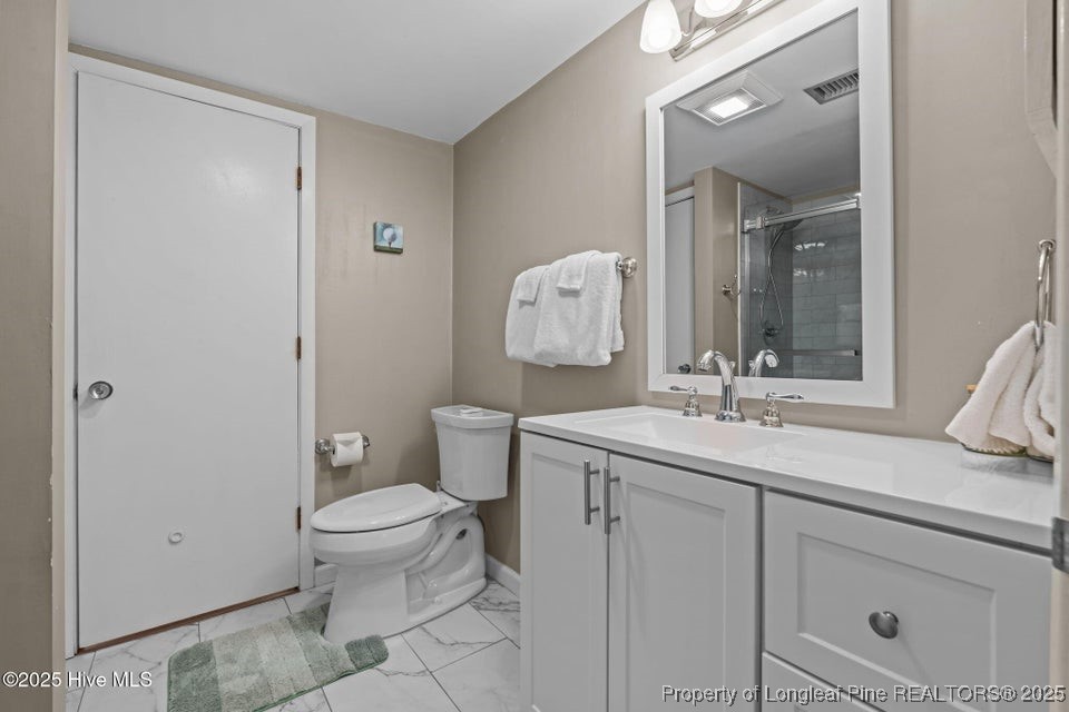 10 Pine Tree Road, Unit 211 Pinehurst, NC 28374 - Photo 26 of 36 a bathroom with a toilet sink and mirror