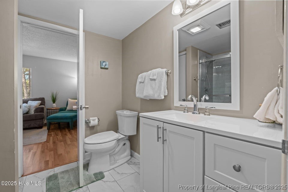 10 Pine Tree Road, Unit 211 Pinehurst, NC 28374 - Photo 27 of 36 a bathroom with a toilet sink and mirror