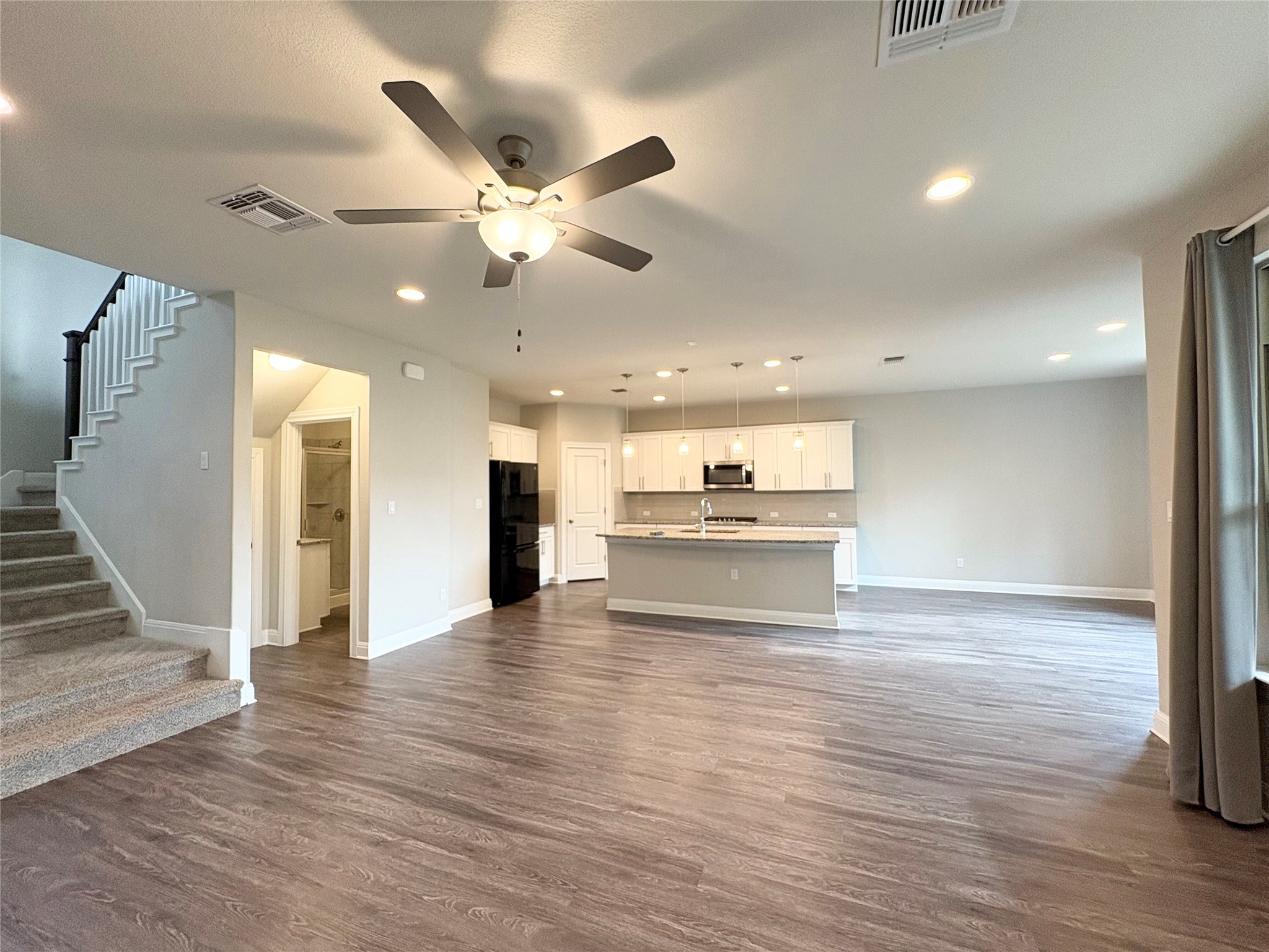 16103 Windroot Street Austin, TX 78728 - Photo 5 of 32 An open layout connects the spacious living area to a modern kitchen with island.