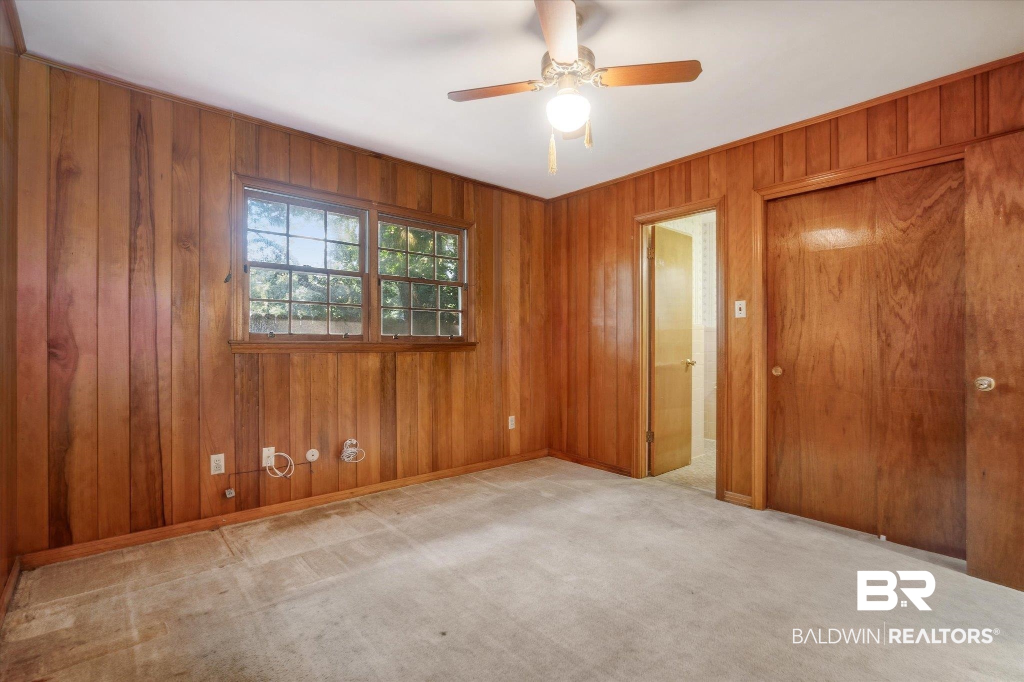 1252 Helm Circle Mobile, AL 36693 - Photo 12 of 18 Unfurnished bedroom featuring ceiling fan, light carpet, and wooden walls