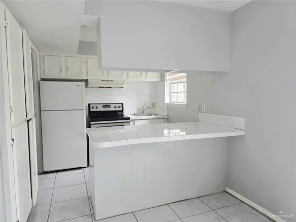 a kitchen with a stove and white cabinets