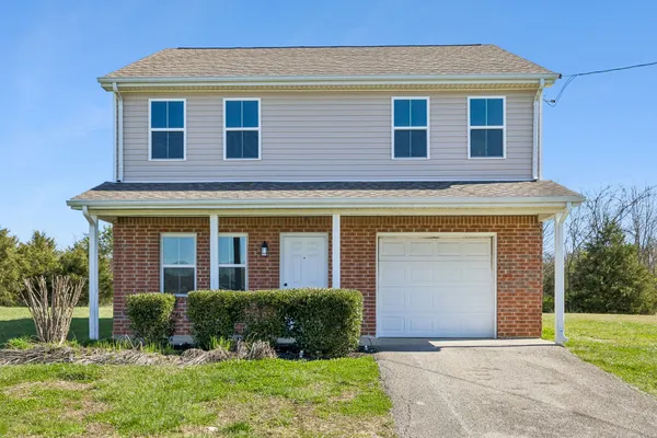 a front view of a house with a yard and garage