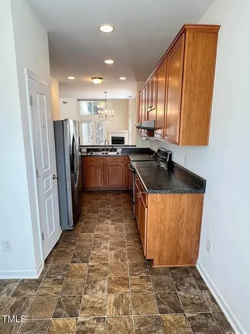 a kitchen with stainless steel appliances granite countertop a refrigerator and a sink