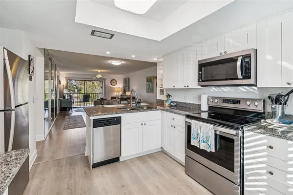 a kitchen with stainless steel appliances granite countertop a stove a refrigerator and a microwave