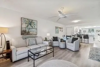 a living room with furniture a ceiling fan and a window
