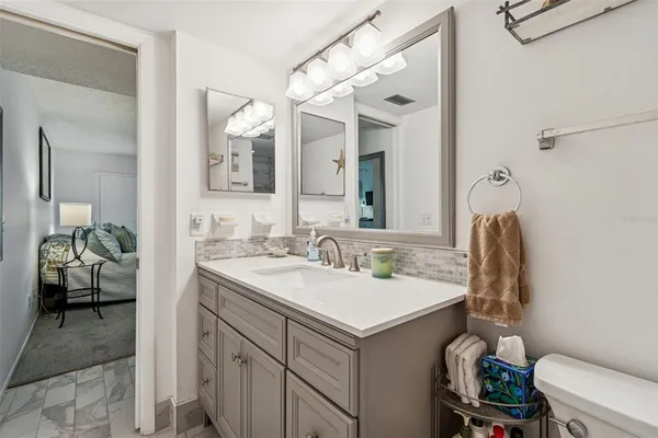 a bathroom with a sink a toilet and a mirror