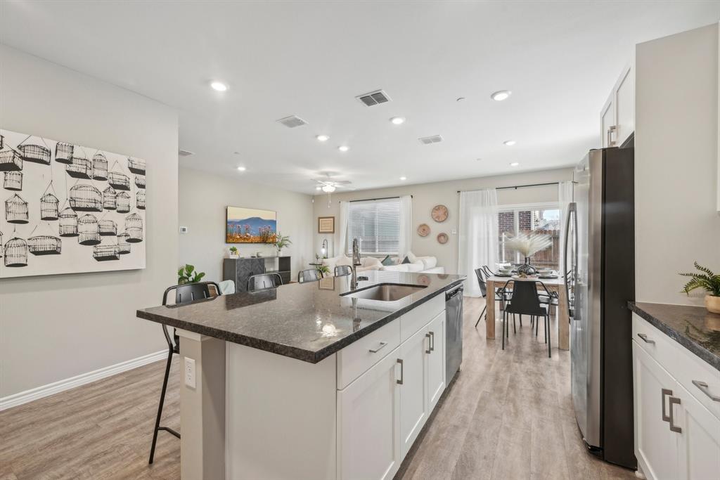 4430 Prairie Crossing, Unit 100 Prosper, TX 75078 - Photo 14 of 38 a kitchen with stainless steel appliances granite countertop a sink and cabinets